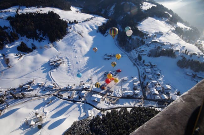 Verschneites Filzmoos mit Ballonen, die im Ort starten