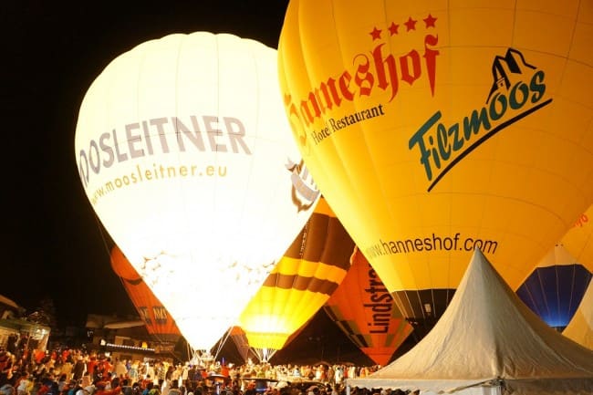 Hell leuchten die Ballone im verschneiten Filzmoos am Fuße der Bischofsmütze
